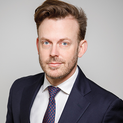 Author profile pic of Gady in a navy suit staring straight into the camera