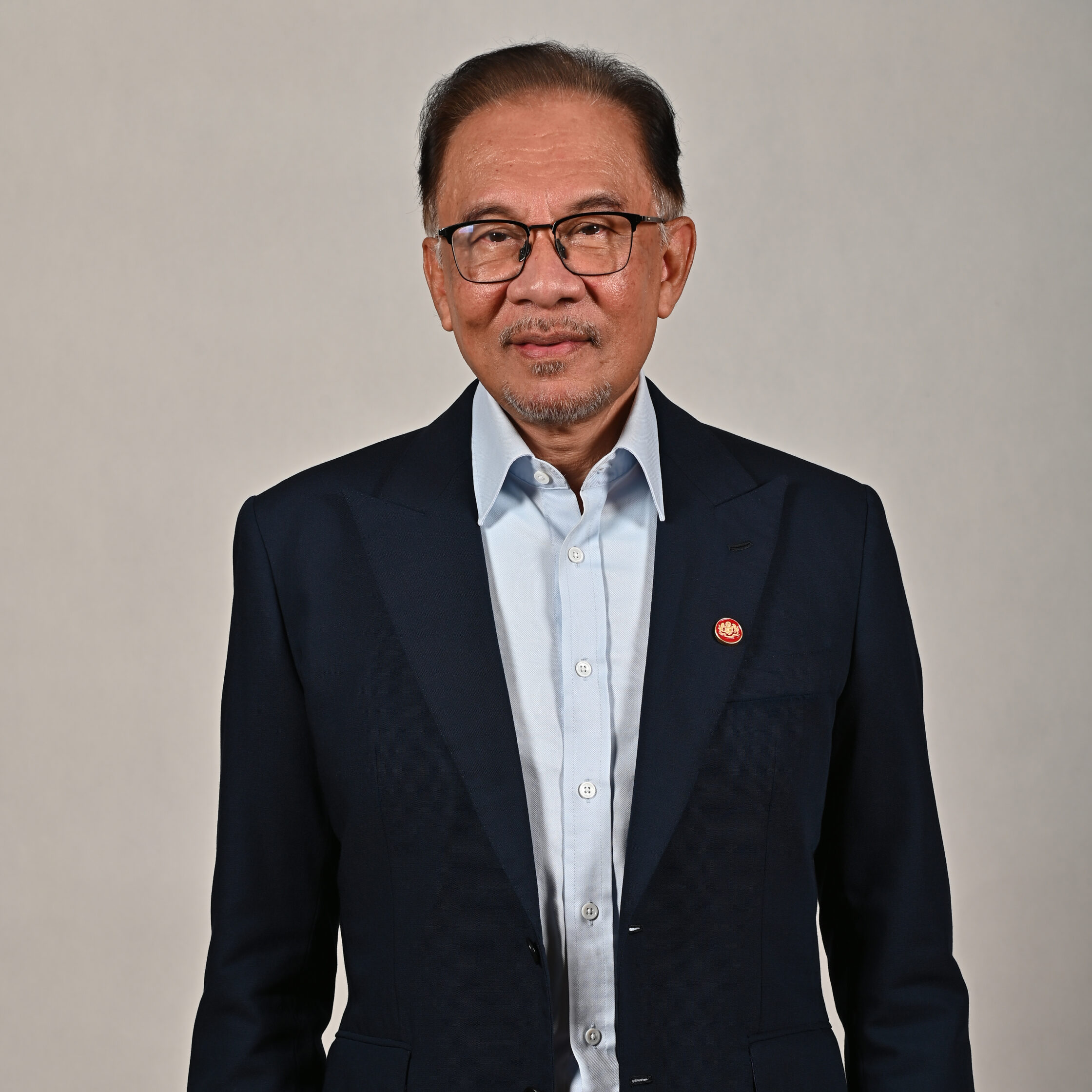 Author photo for Prime Minister Anwar Ibrahim of Malaysia. He is wearing glasses and a pale blue shirt with a navy suit coat.