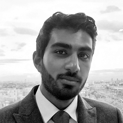 Author profile pic looking at the camera in front a cityscape