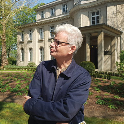 Profile pic of author Christopher Hale showing a man in profile in front of a large house.