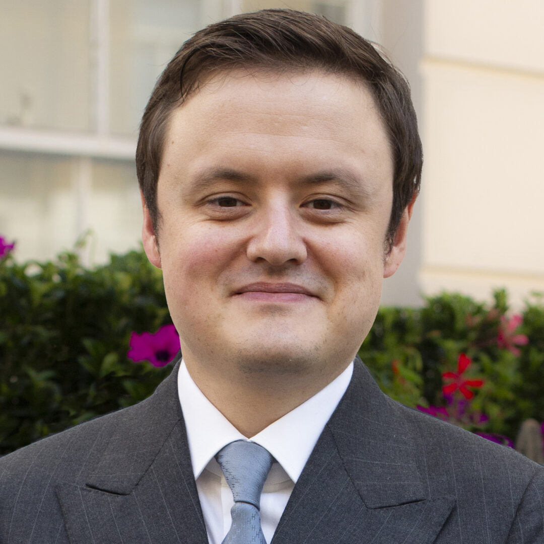 Author photo of Edward Howell showing a smiling man wearing a suit jacket and tie.