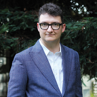 Author profile pic standing in front of greenery