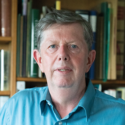 Author profile pic in front of a bookshelf